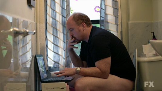 louie-in-the-bathroom-with-his-laptop-and-a-cigarette.png
